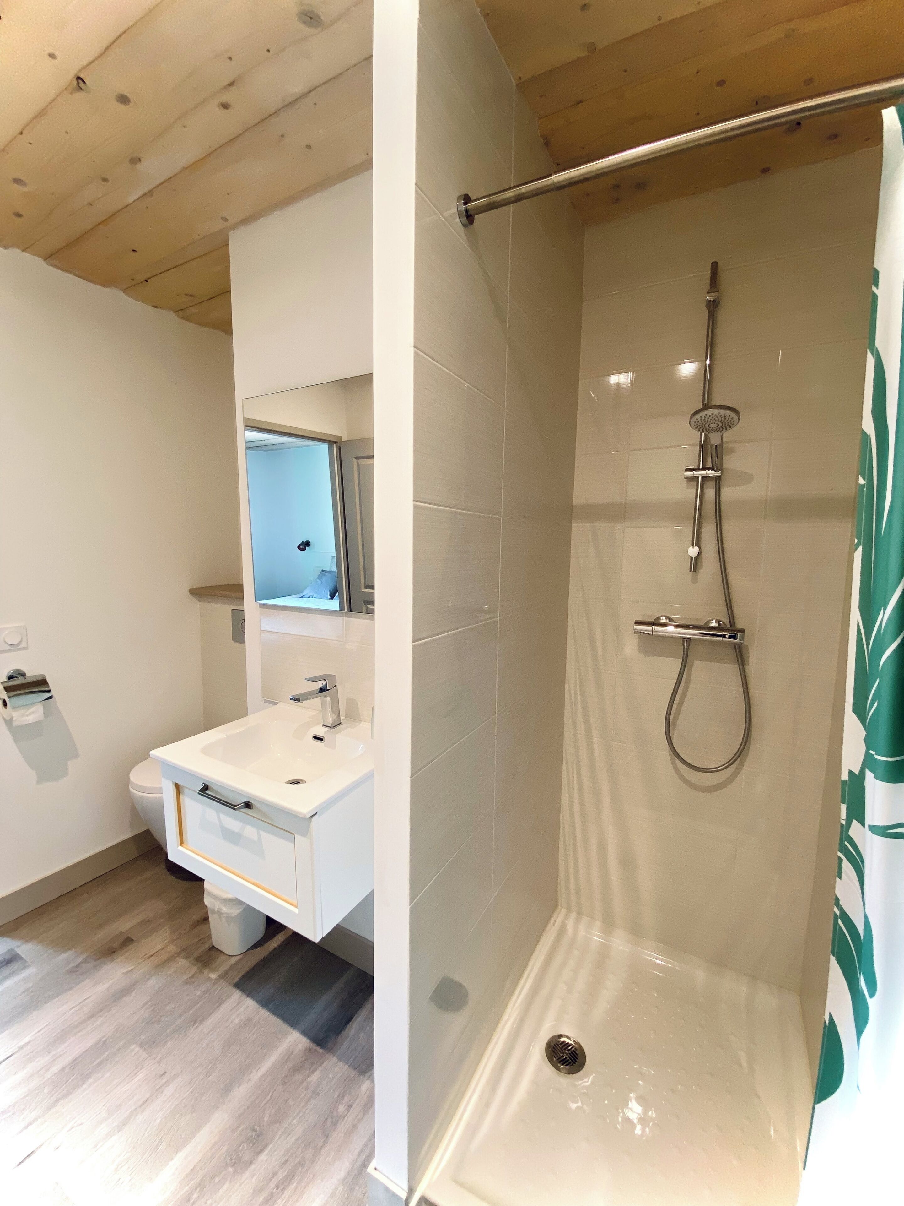 Et moderne badeværelse med bruser, vask og toilet.