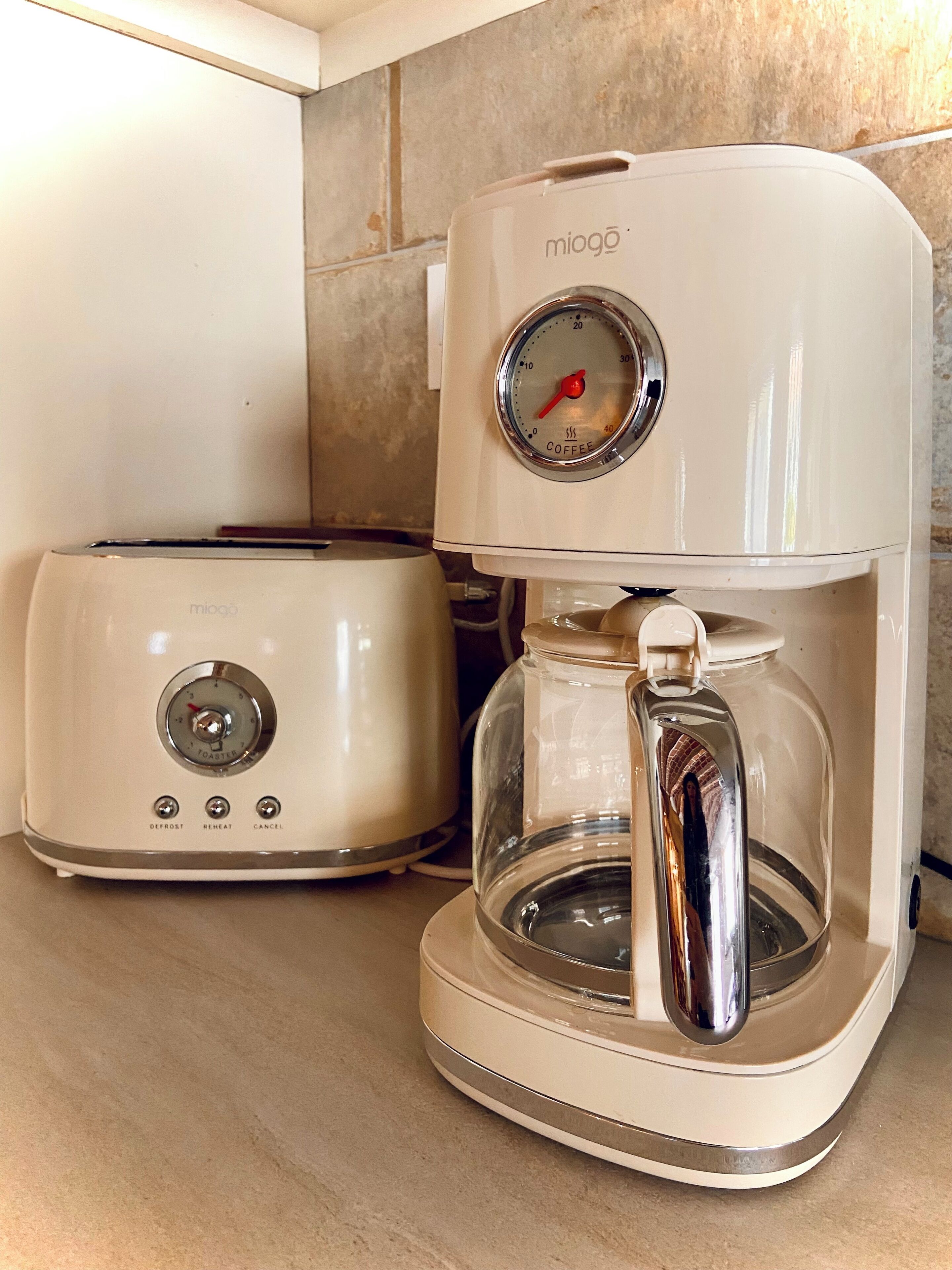 Une cuisine avec un grille-pain blanc et une machine à café.