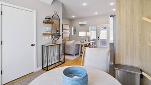 Een moderne woonkamer met een bank, een eettafel en een keuken met een fornuis.