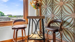 A room with two wooden chairs, a small table, and a decorative wall panel.