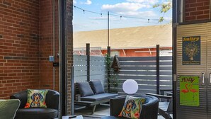 Un espace extérieur aménagé avec des murs en briques, une clôture en bois et un panneau publicitaire pour les boissons.