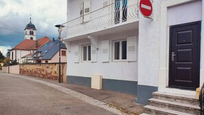 A building with a white facade, a black door, and a balcony with white railings. - Glamorous flat in Mertzwiller (Mertzwiller)