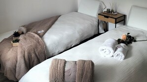 A hotel room with two beds, a nightstand with a lamp, and framed artwork on the walls. - Glamorous flat in Mertzwiller (Mertzwiller)