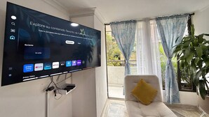 A living room with a flat-screen TV mounted on the wall displaying various streaming apps. - Medellín Poblado Gem • Walk to Provenza & Lleras (Medellín)