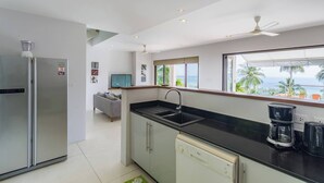 A modern kitchen with a refrigerator, dishwasher, and coffee maker. - Serene Bay View Villa in Ko Samui - Your Tropical Paradise (Koh Samui)