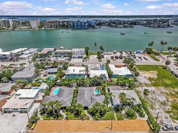 Vista aérea de una zona residencial costera con edificios, un puerto deportivo y una vista despejada del agua.