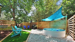A backyard with a pool, a blue chair, and a wooden fence. - The Tropical Palms ~ Cowboy Pool ~ Private yard. (St. Augustine)