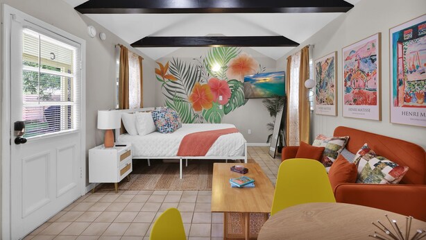A cozy room with a bed, a wooden table, and a sofa. - The Tropical Palms ~ Cowboy Pool ~ Private yard. (St. Augustine)