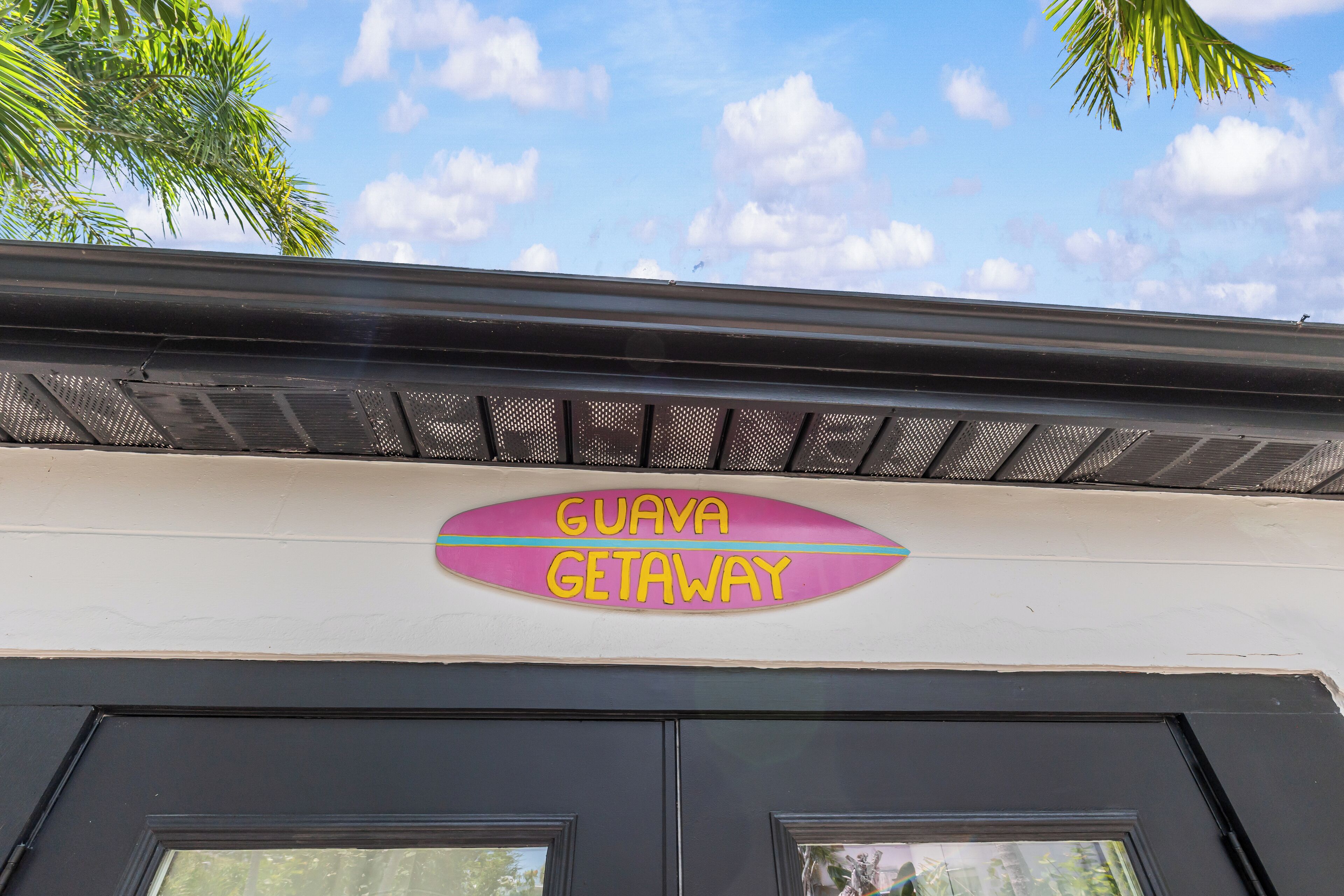 A sign for "Guava Getaway" on a building's facade.