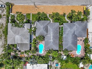 A residential area with multiple houses, each with a swimming pool and surrounded by palm trees. - Guava getaway freshly renovated unit September 2025 heated pools (Clearwater)