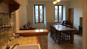 Una cocina con una mesa y sillas de madera, una ventana y un radiador.
