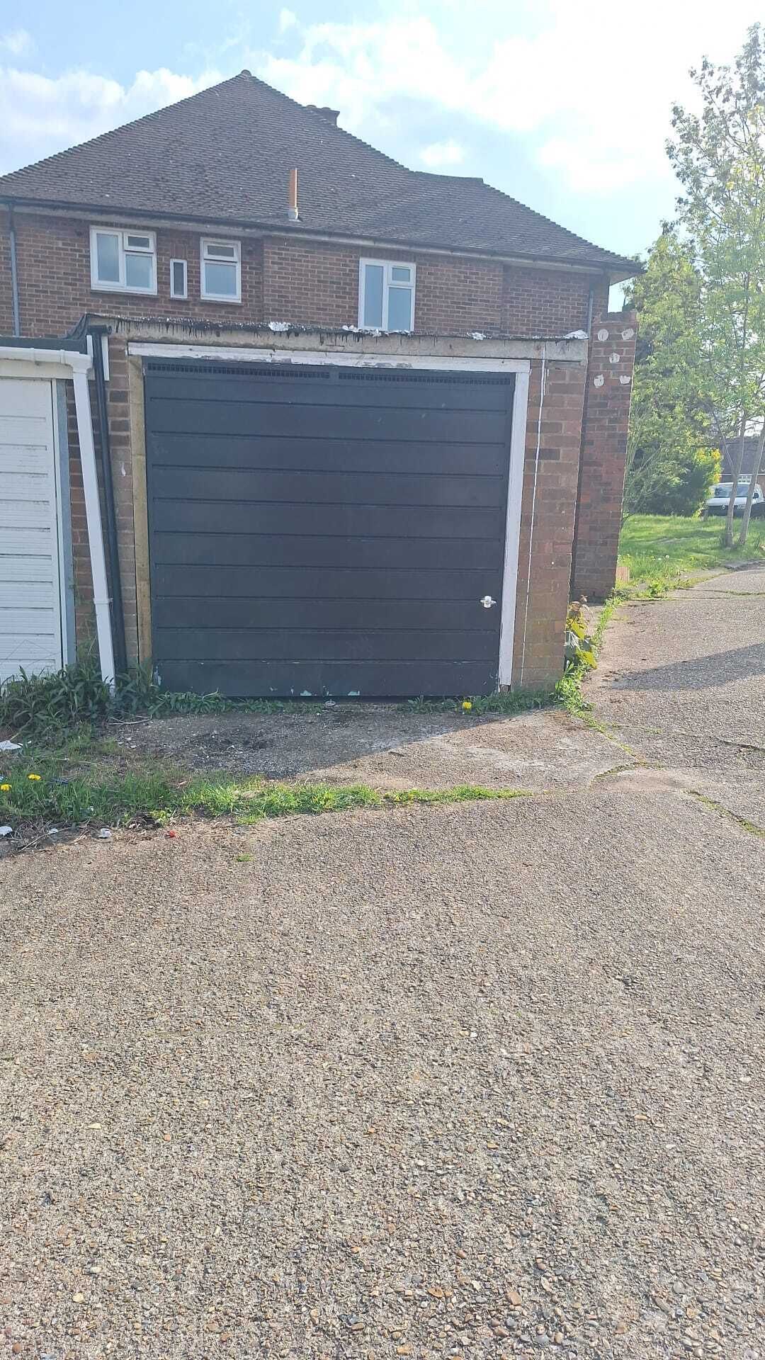 A residential garage with a gravel driveway.