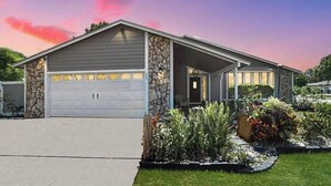 Einbungalow mit Garage, Steinhausfassade und einem gepflegten Garten.