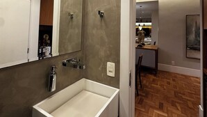 A modern bathroom with a large rectangular sink, a mirror, and a wooden floor. - Copacabana 3BR • 1 Block to the Beach — Stylish & Family-Friendly (Rio de Janeiro)