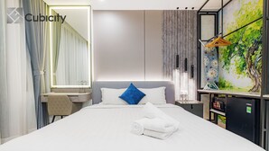 A modern hotel room with a large bed, a desk, a mirror, and a wall-mounted TV. - Cubicity Pho Duc Chinh (Ho Chi Minh Municipality)