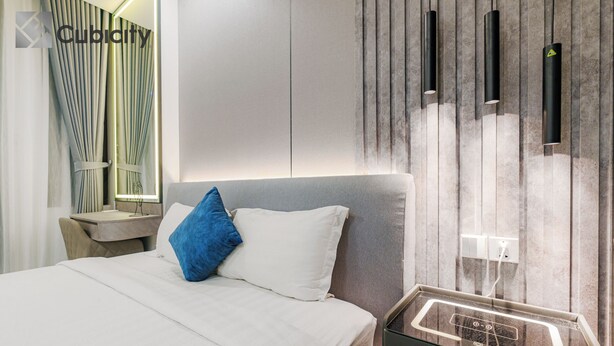 Ein modernes Hotelzimmer mit Bett, Nachttisch und einer Ablagefläche mit Ladestation.