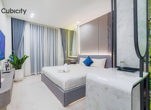 Una habitación de hotel moderna con una cama grande, un escritorio, un televisor y una planta en maceta.