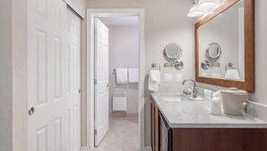 A modern bathroom with a double sink, a large mirror, and a walk-in shower. - Bayside King Ocean Front Island Views (Eastsound)