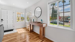 A modern bathroom with a wooden vanity, a large mirror, and a view of the outside through a window. - East SJ Entire 4Br Home Quiet (San Jose)