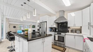 A modern kitchen with white cabinets, stainless steel appliances, and a central island. - Entire 3br House With Playground (Palo Alto)