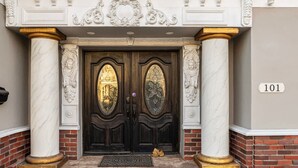 A grand entrance with a dark wooden door, flanked by white marble columns and intricate carvings. - Stunning Roman Design 7bed5bath in Heart San Jose (San Jose)