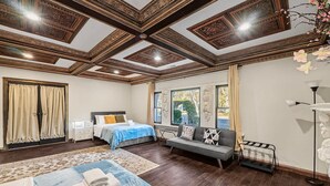 A spacious bedroom with a large bed, a sofa, and a desk.