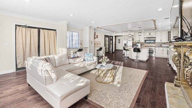 A spacious living area with a sofa, a coffee table, and a kitchen in the background. - Spaciour 4Br 4bth Stunning House With Free Parking (San Jose)