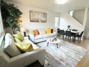 Un salon moderne avec un canapé, une table basse et un coin repas.