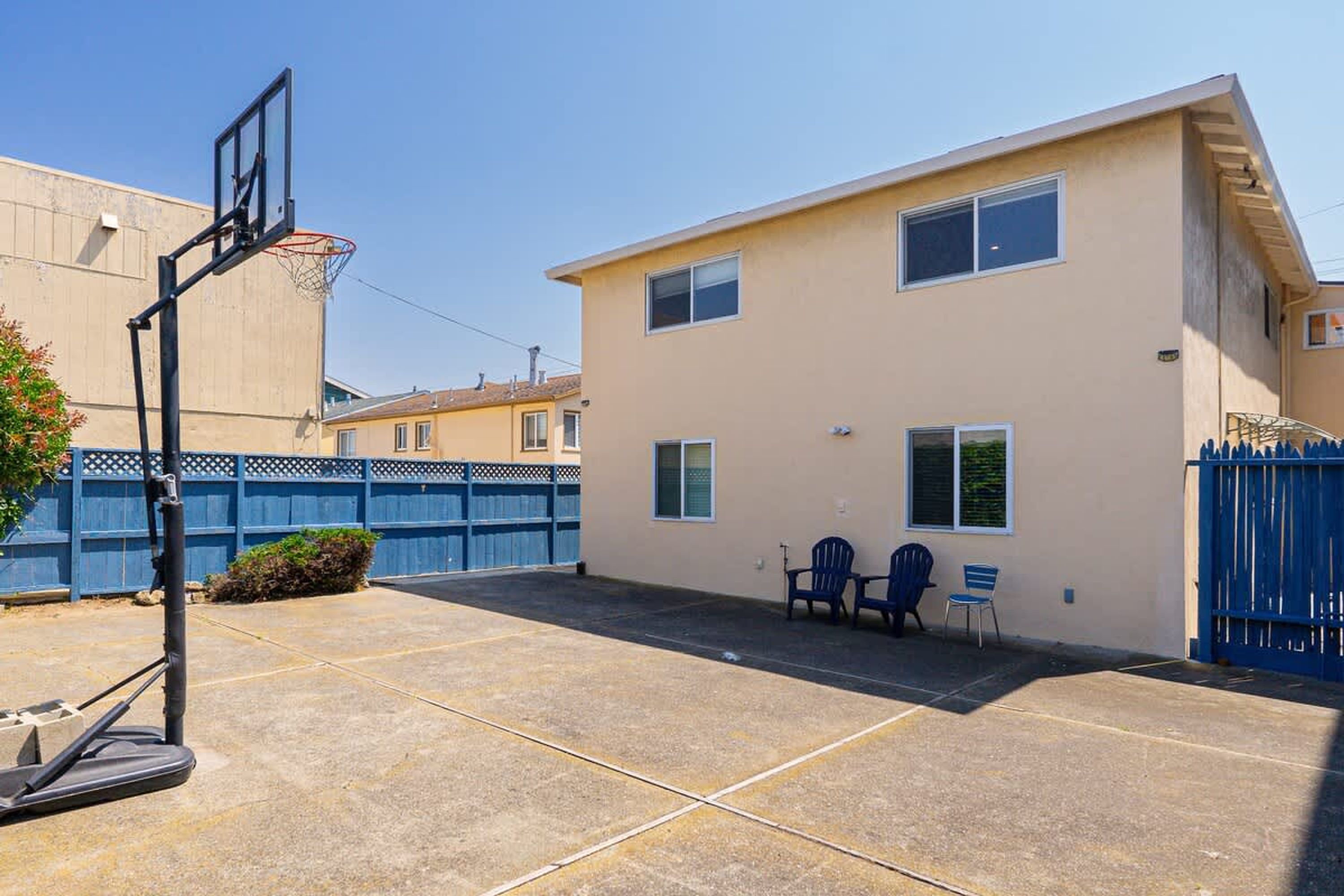 Un edificio a due piani con un canestro da basket nel cortile.