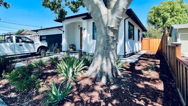 A modern two-story house with a large tree in the front yard, a driveway, and a wooden fence. - New 3b3b Home Gogle Speed Wifi (Sunnyvale)