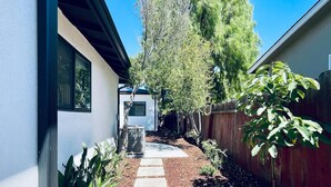 A narrow pathway leading to a house with a white exterior and a wooden fence on one side. - New 3b3b Home Gogle Speed Wifi (Sunnyvale)