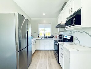 A modern kitchen with white cabinets, a stainless steel refrigerator, a microwave, and a stove. - New 3b3b Home Gogle Speed Wifi (Sunnyvale)