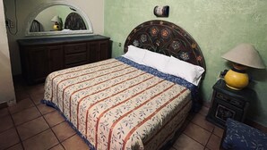 A bedroom with a bed, dresser, mirror, and a lamp. - Meson Acueducto (Querétaro)