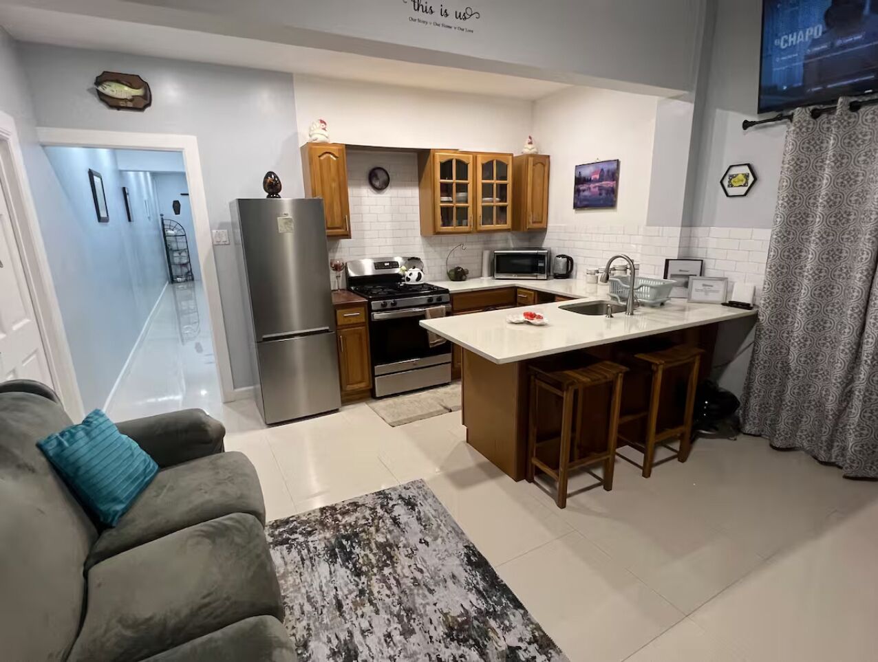 Una cocina compacta con una isla central, armarios de madera y un refrigerador.