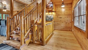 A wooden staircase with a railing, a ceiling fan, and a window with blinds. - Mountain Views, 🎯Game Room, Sleeps 20, Near Dollywood & Gatlinburg (Sevierville)