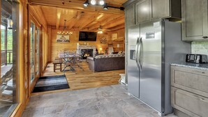 A spacious kitchen with wooden ceiling, a stone floor, and a large refrigerator. - Mountain Views, 🎯Game Room, Sleeps 20, Near Dollywood & Gatlinburg (Sevierville)