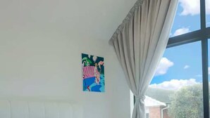 Een slaapkamer met een groot bed, uitzicht op de lucht en een schilderij aan de muur.