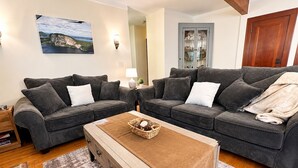 A living room with two grey sofas, a wooden coffee table, and a patterned rug.