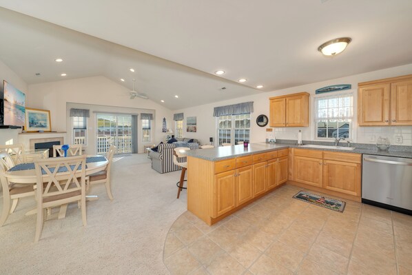 A spacious kitchen with wooden cabinets, a large island, and a dishwasher.