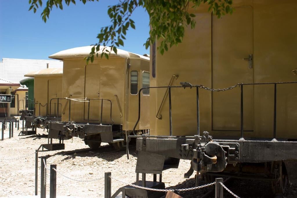 Vintage train cars parked outdoors, with chains securing them.