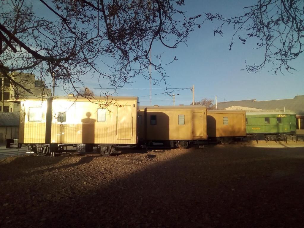 A train with several yellow and green carriages parked on a track.