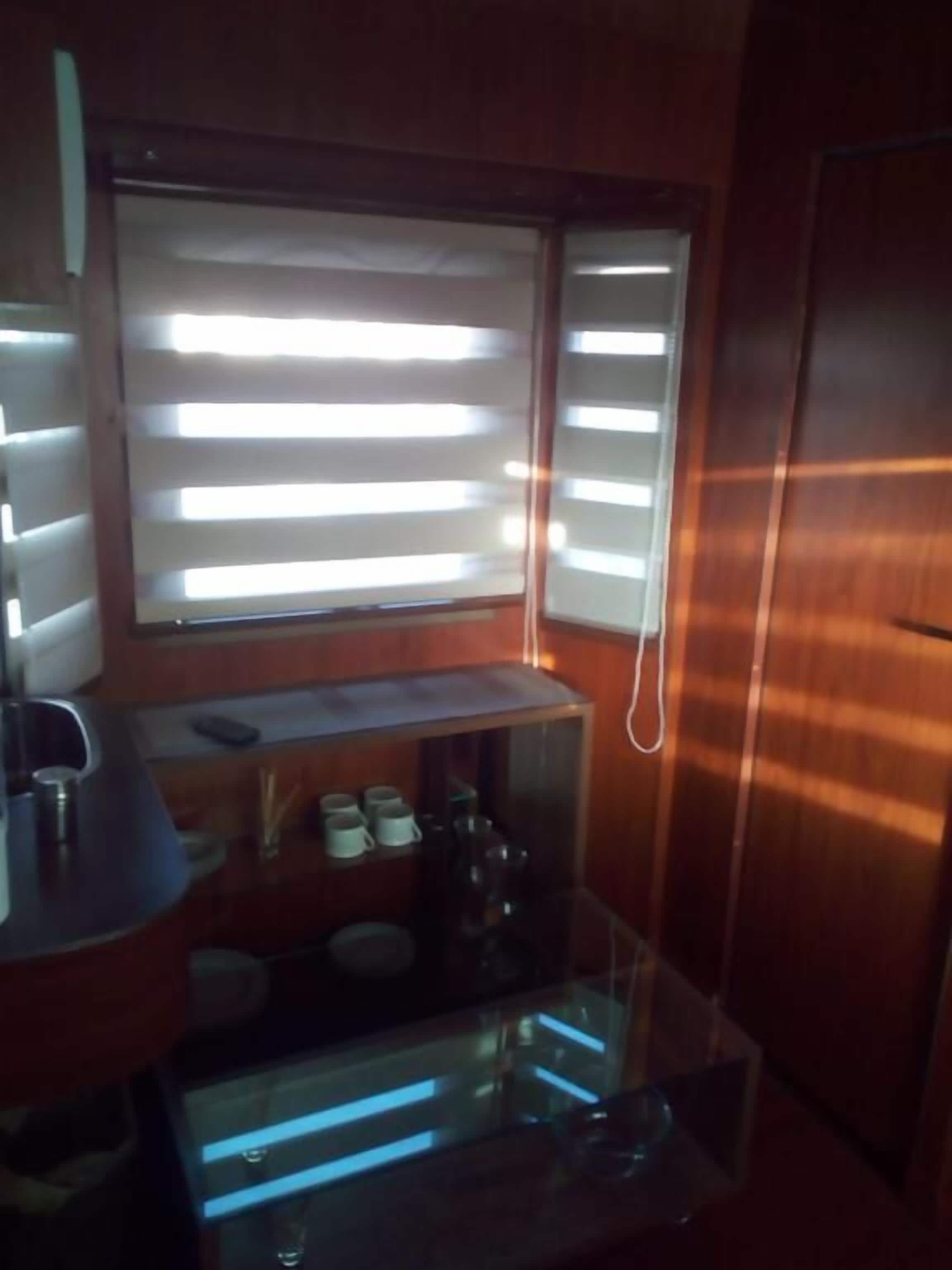 Una cocina compacta con ventana, cafetera y una pequeña encimera.