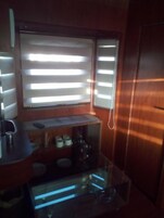 Una cocina compacta con ventana, cafetera y una pequeña encimera.