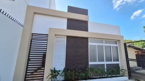A modern two-story house with a large window and a small balcony. - apto-wifi6-tvstreaming (Panamá)