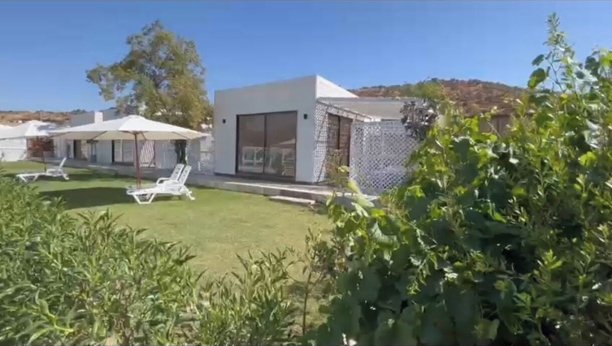 Uma villa moderna com um pátio amplo, piscina e um jardim privativo.