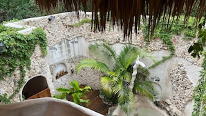 A stone-walled courtyard with a small pool, potted plants, and a wooden bench. - Casa Yaxunah II 30 min from Chichen (Yaxuna)