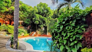 A swimming pool surrounded by lush greenery and palm trees. - Hotel Eterna Primavera Cuernavaca (Cuernavaca)