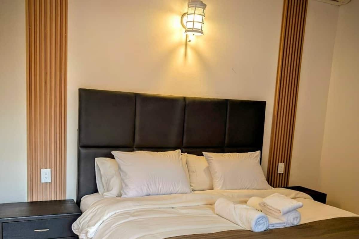 Cubrecamas, espacio para trabajar con laptop y cortinas blackout