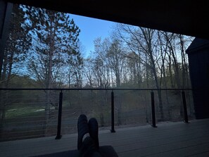 Blick von einem Balkon mit GelÀnder, bewölkter Himmel und BÀume im Hintergrund.
