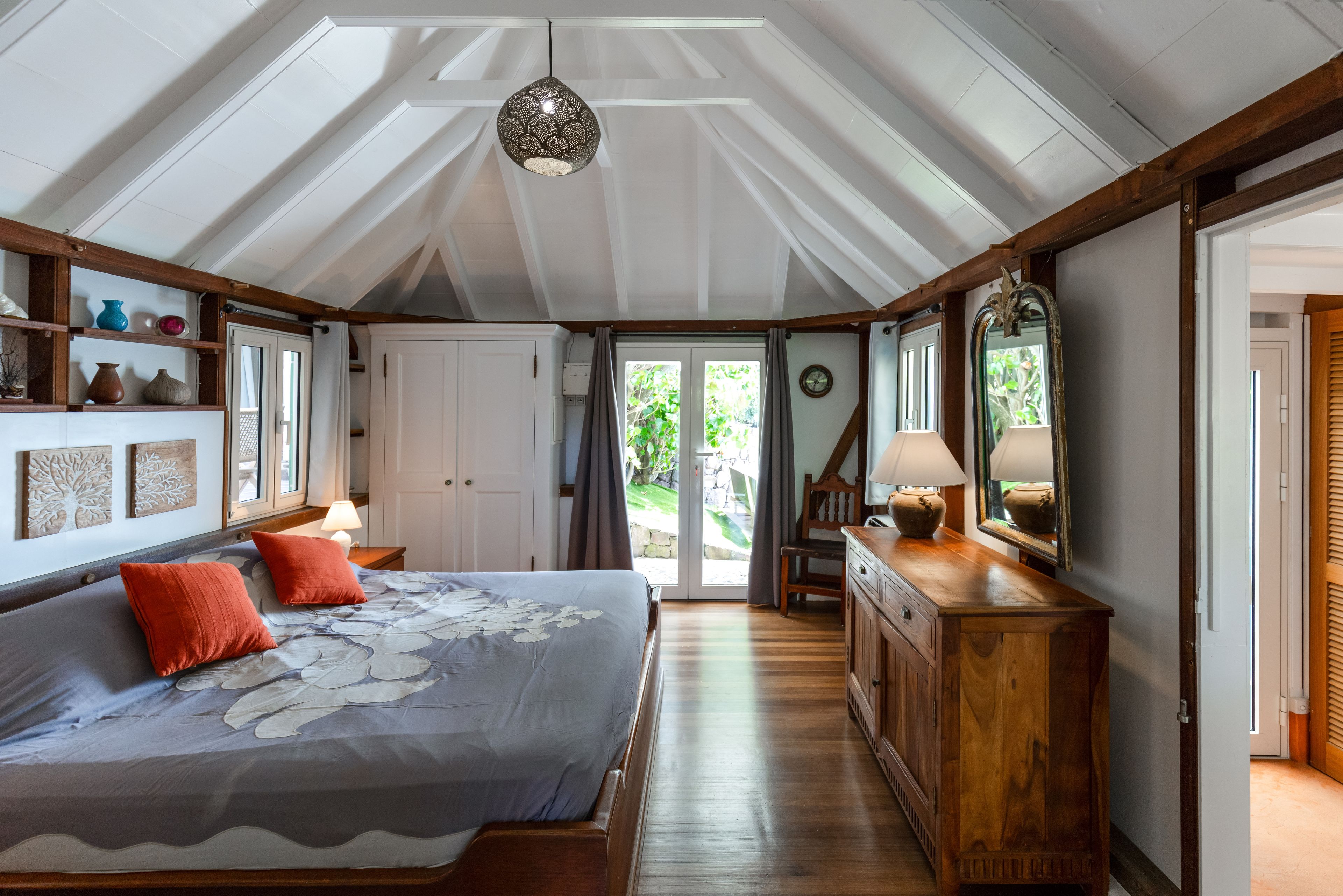 Una camera da letto con un letto grande, una cassettiera in legno e una ventola a soffitto.